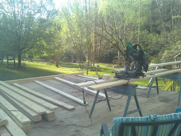 Miter saw and framing lumber on a deck under construction in Aleppo