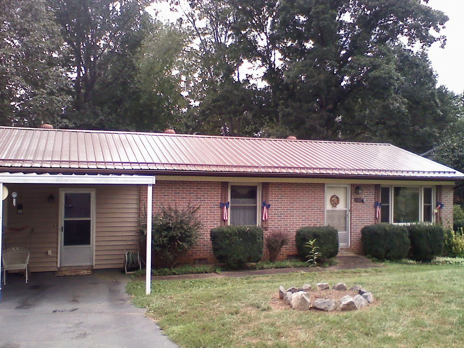 Bronze metal roof and carport on a brick ranch home — Roof Repair work by our crew in Aleppo